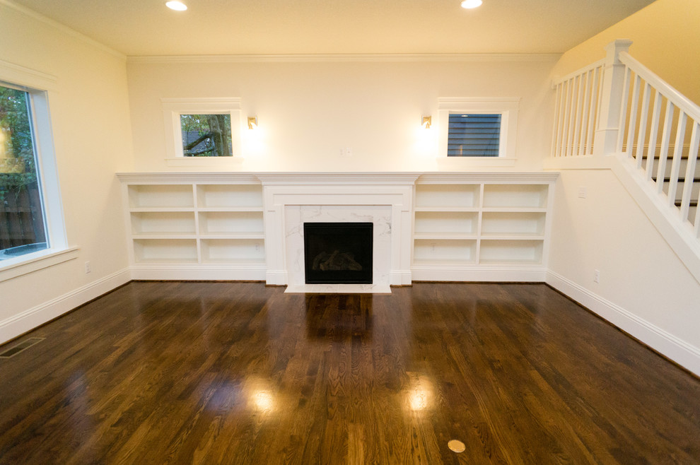 Mittelgroßes, Offenes Rustikales Wohnzimmer mit beiger Wandfarbe, braunem Holzboden, Kamin, Kaminumrandung aus Stein und TV-Wand in Portland