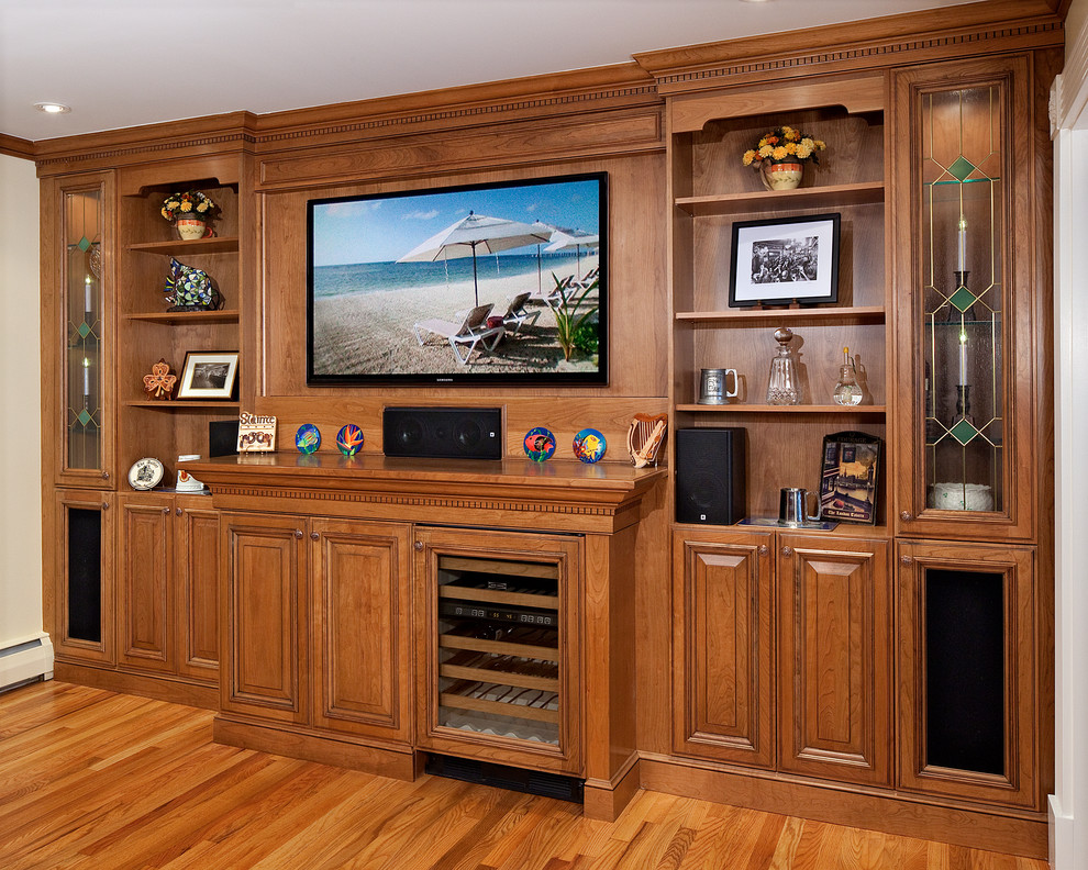This is an example of a medium sized classic open plan living room in New York with a home bar, medium hardwood flooring, a built-in media unit, white walls and no fireplace.