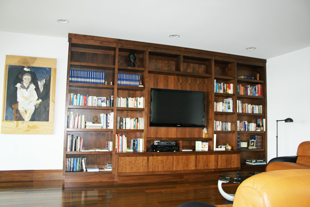 Bild på ett stort funkis vardagsrum, med vita väggar, mellanmörkt trägolv och en inbyggd mediavägg
