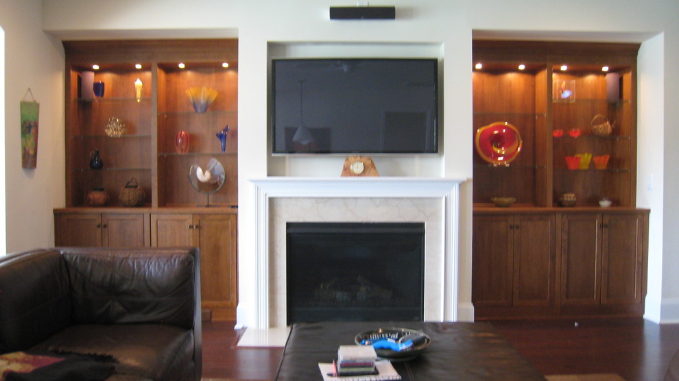 Mittelgroßes, Offenes Modernes Wohnzimmer mit weißer Wandfarbe, dunklem Holzboden, Kamin, Kaminumrandung aus Stein und TV-Wand in Nashville