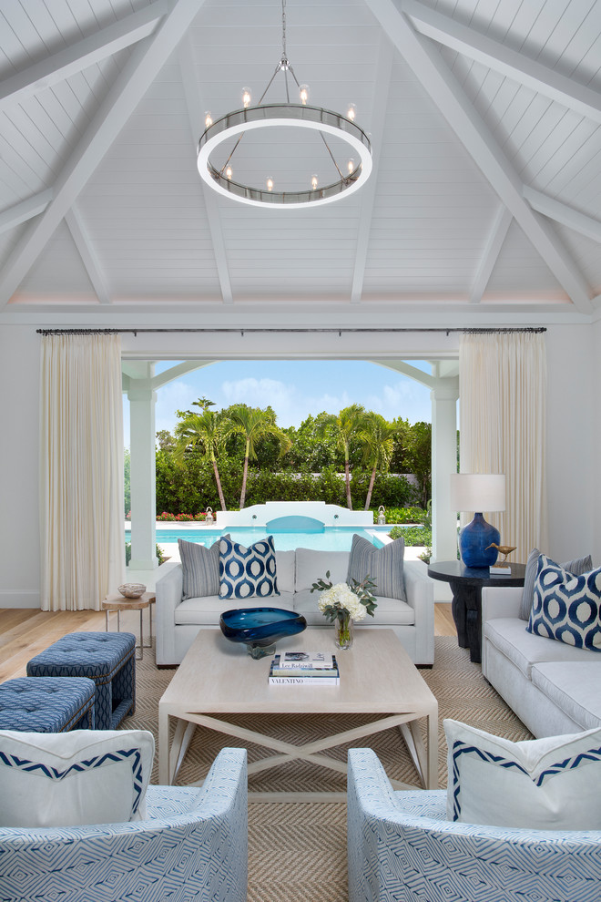 Esempio di un grande soggiorno stile marino aperto con pareti bianche, pavimento in legno massello medio e pavimento marrone
