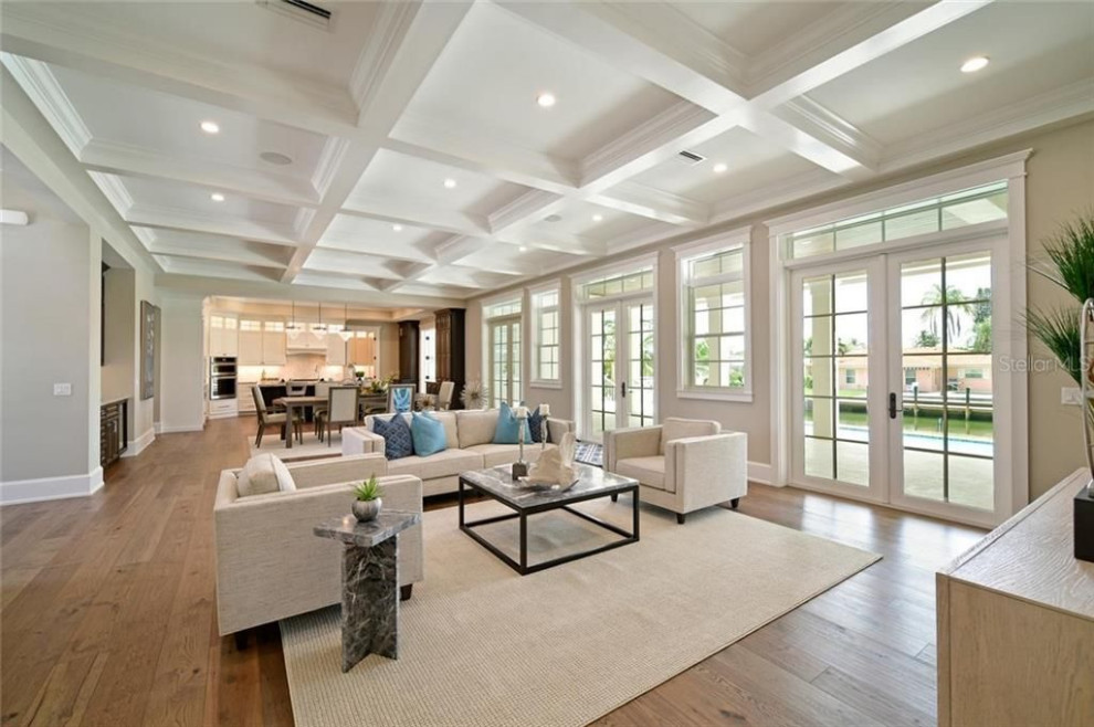 Offenes Maritimes Wohnzimmer mit beiger Wandfarbe, braunem Holzboden, braunem Boden und eingelassener Decke in Tampa