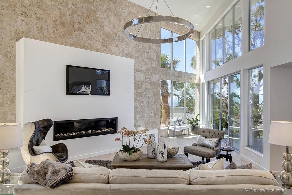 This is an example of a large contemporary formal open plan living room in San Diego with grey walls, light hardwood flooring, a ribbon fireplace, a plastered fireplace surround, a wall mounted tv and beige floors.