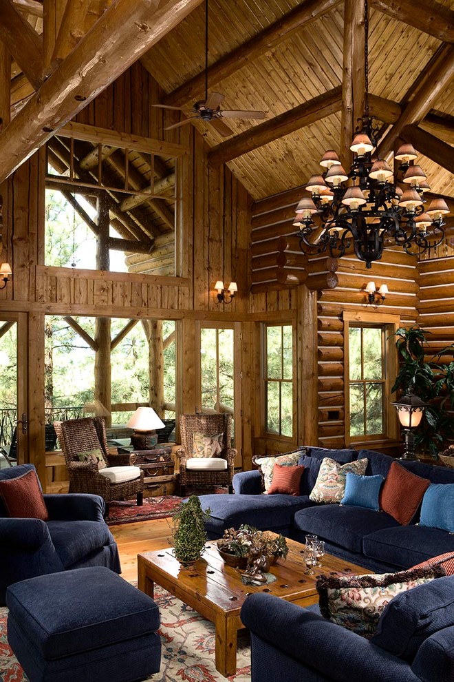 Источник вдохновения для домашнего уюта: открытая гостиная комната в стиле рустика с коричневыми стенами, паркетным полом среднего тона и синим диваном