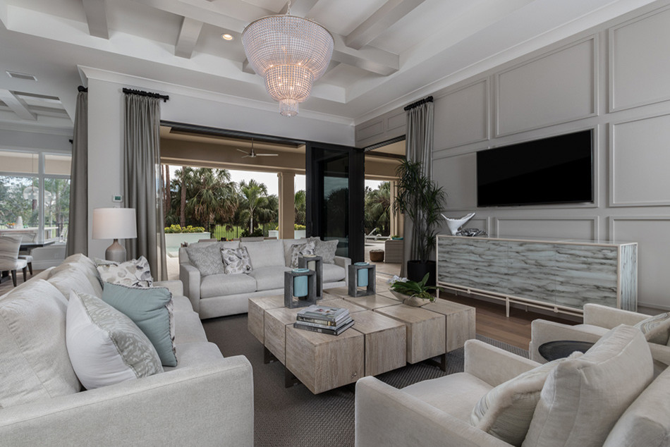 Esempio di un soggiorno mediterraneo di medie dimensioni e aperto con sala formale, pareti grigie, parquet chiaro, TV a parete e pavimento beige