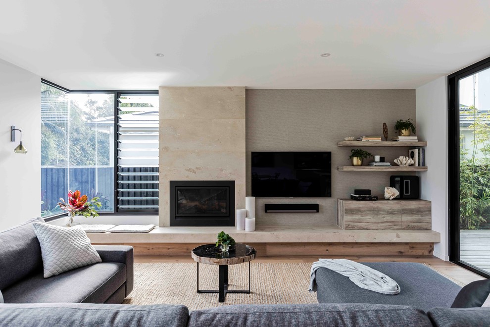 Inspiration för mellanstora moderna vardagsrum, med vita väggar, ljust trägolv, en standard öppen spis, en spiselkrans i trä och en väggmonterad TV
