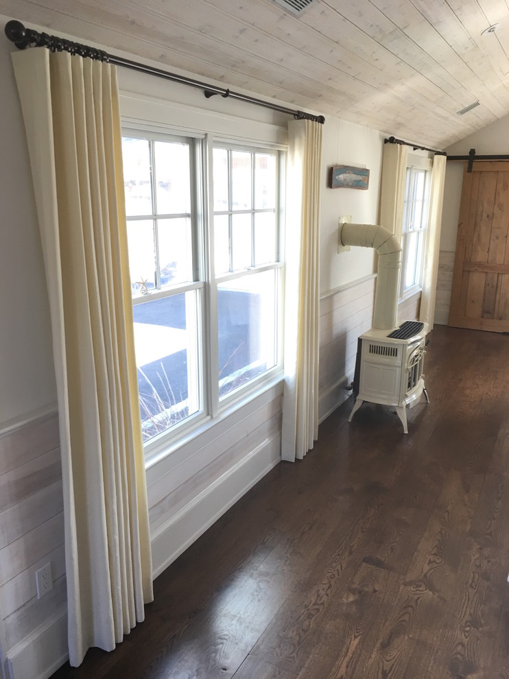 Mittelgroßes, Fernseherloses, Offenes Klassisches Wohnzimmer mit weißer Wandfarbe, dunklem Holzboden, Kaminofen und braunem Boden in New York