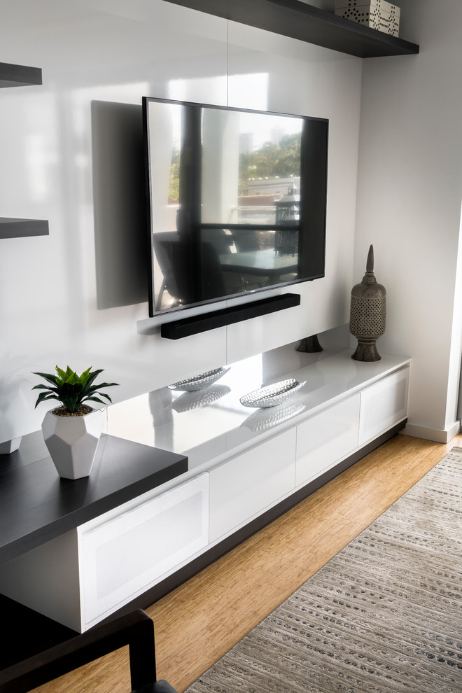 Foto di un piccolo soggiorno moderno aperto con pareti grigie, parquet chiaro e TV a parete