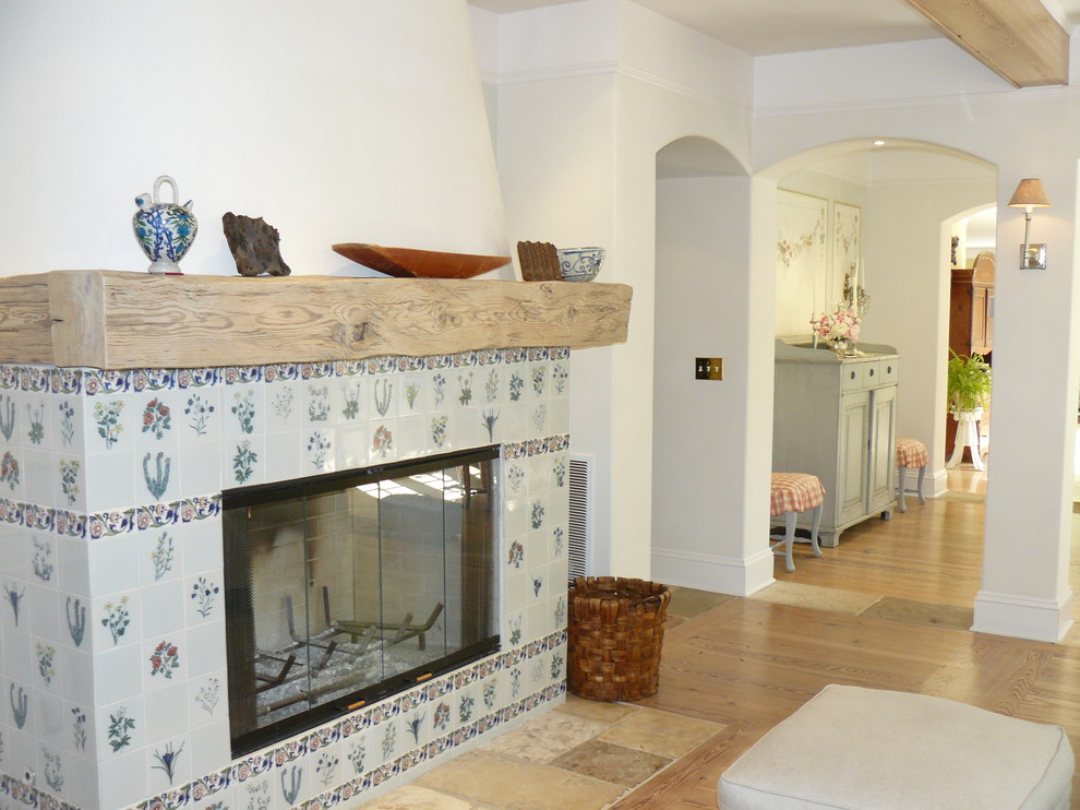 Стильный дизайн: гостиная комната в классическом стиле с белыми стенами, стандартным камином и фасадом камина из плитки - последний тренд