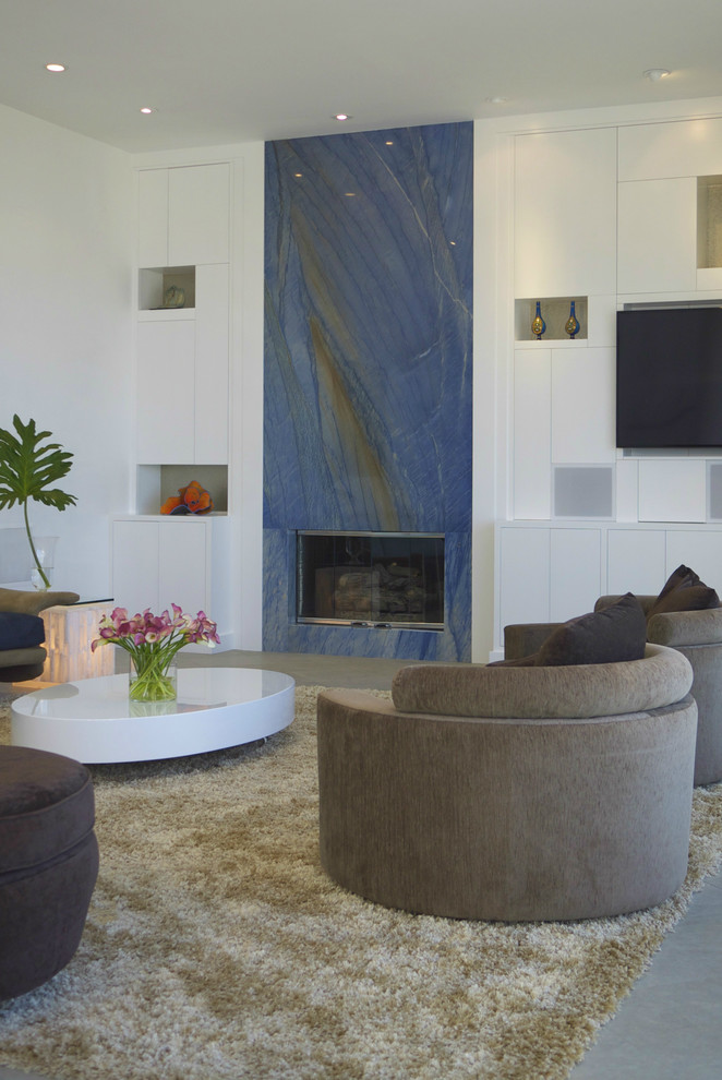 Example of a large trendy open concept slate floor living room design in Orange County with white walls, a standard fireplace, a stone fireplace and a media wall