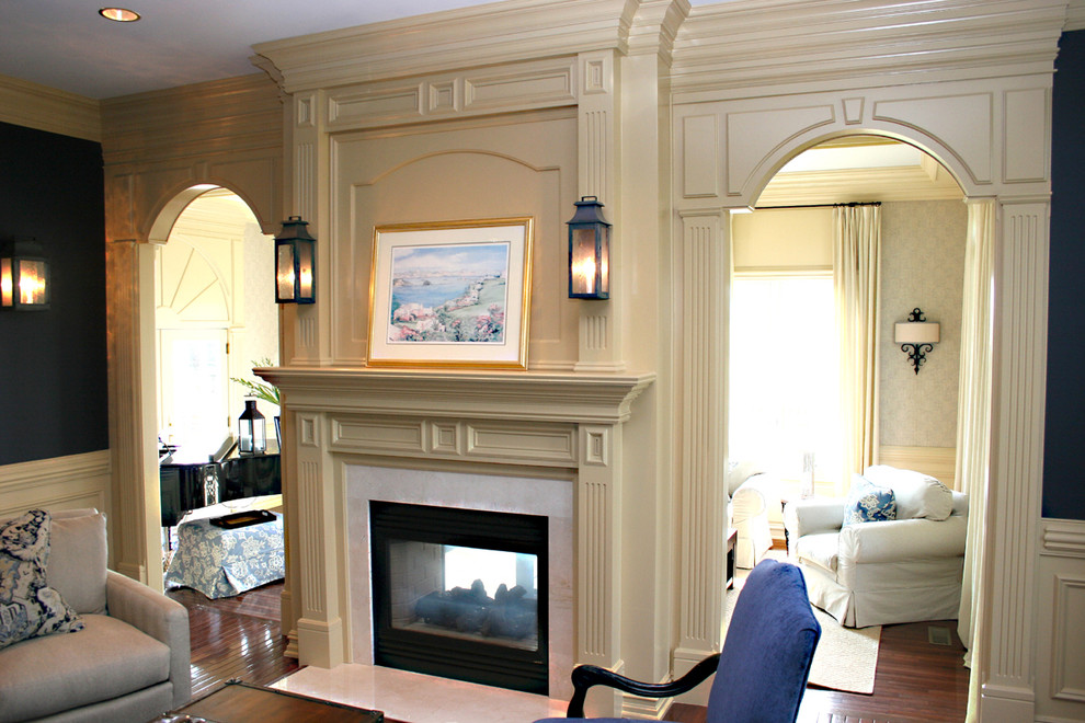 Источник вдохновения для домашнего уюта: открытая гостиная комната среднего размера в классическом стиле с синими стенами, паркетным полом среднего тона, двусторонним камином, фасадом камина из дерева и коричневым полом без телевизора