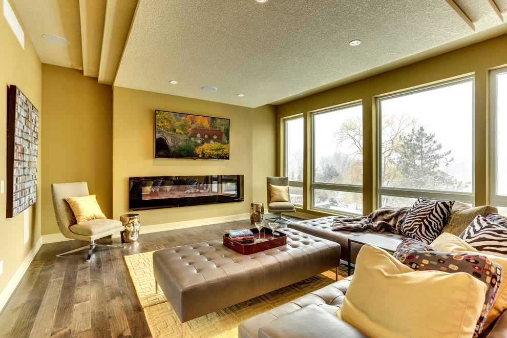 Foto de salón actual con paredes amarillas, suelo de madera clara y chimenea lineal