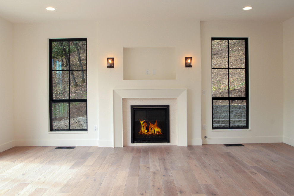 Example of a large minimalist open concept light wood floor and beige floor living room design in Other with white walls, a standard fireplace and no tv