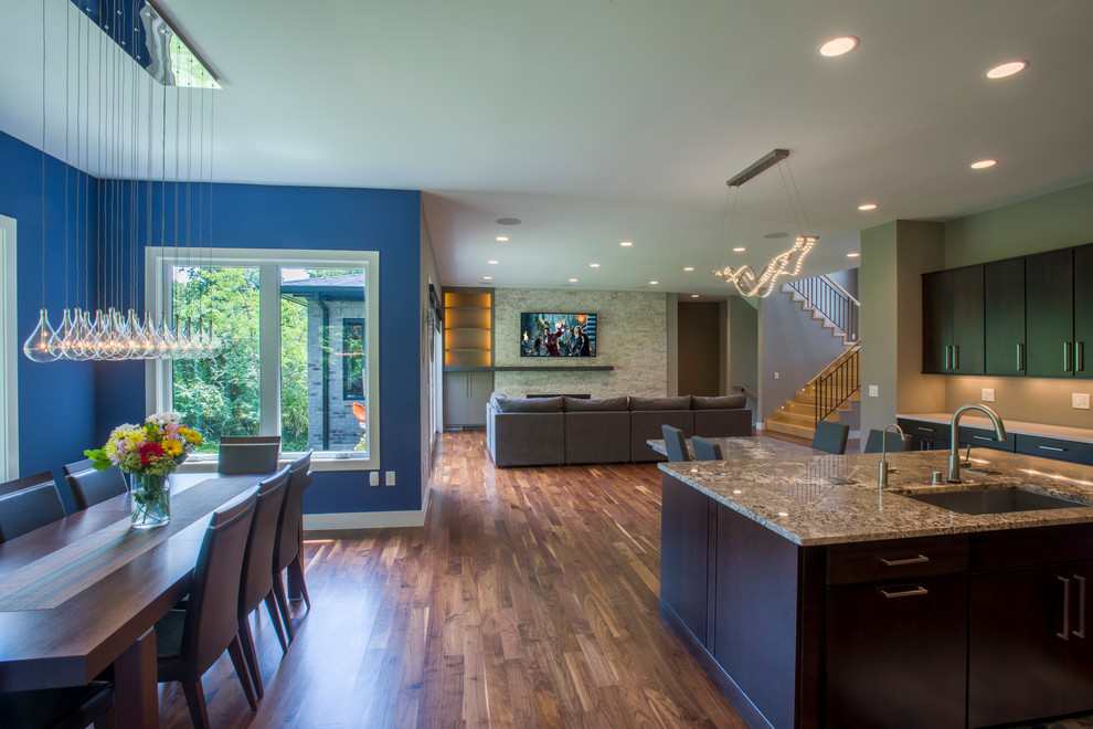 Großes, Offenes Modernes Wohnzimmer mit blauer Wandfarbe, braunem Holzboden, Kamin und Kaminumrandung aus Stein in Cincinnati