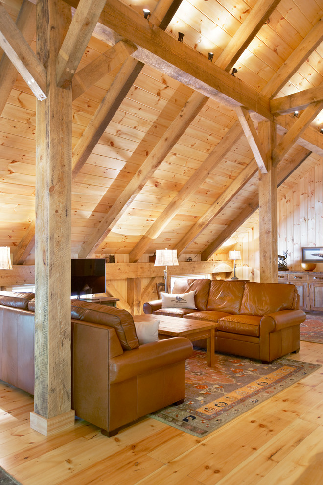 Mittelgroßes Uriges Wohnzimmer mit hellem Holzboden und freistehendem TV in Sonstige