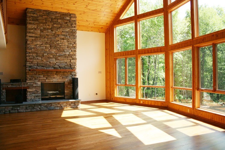 Exemple d'un salon craftsman de taille moyenne et ouvert avec un mur beige, une cheminée standard, un manteau de cheminée en pierre et un sol marron.