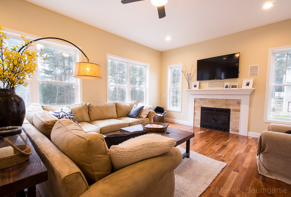 Classic living room in Burlington with beige walls, medium hardwood flooring, a standard fireplace, a brick fireplace surround and a wall mounted tv.