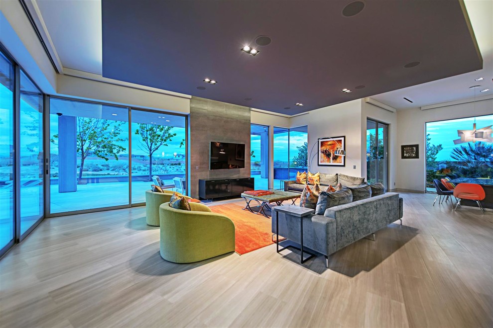 Großes, Repräsentatives, Offenes Modernes Wohnzimmer ohne Kamin mit grauer Wandfarbe, hellem Holzboden, TV-Wand und grauem Boden in Las Vegas