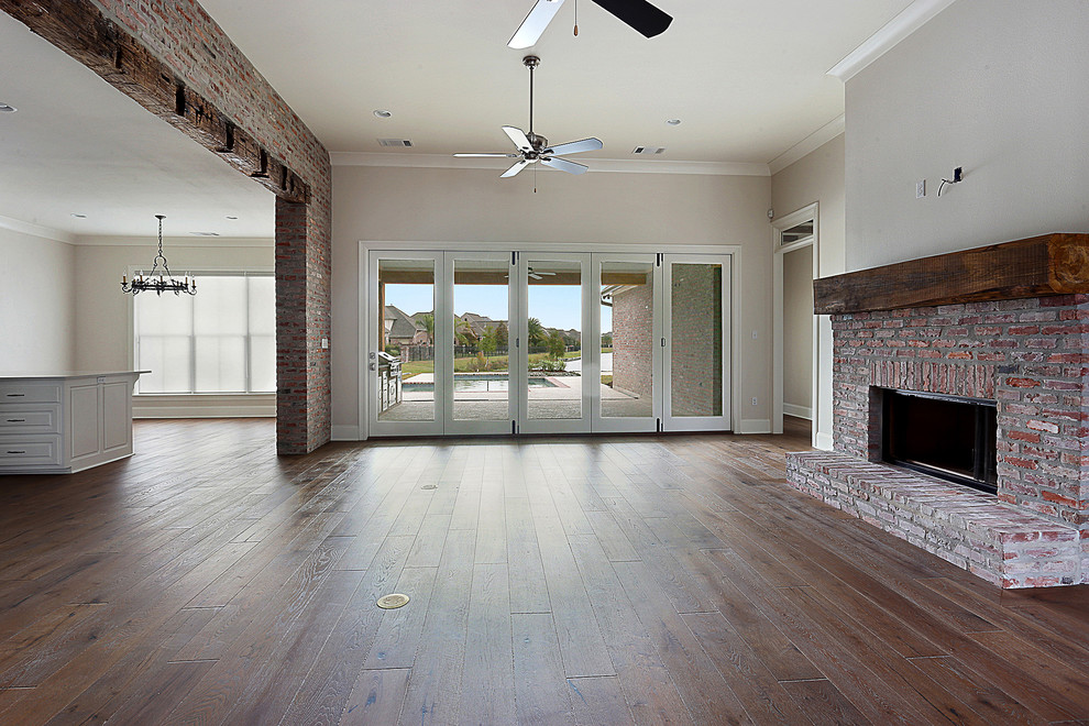 Großes, Offenes Rustikales Wohnzimmer mit weißer Wandfarbe, dunklem Holzboden, Kaminumrandung aus Backstein und Gaskamin in Orange County