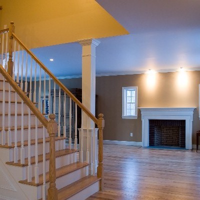 Mittelgroßes, Offenes Klassisches Wohnzimmer mit beiger Wandfarbe, hellem Holzboden, Kamin und Kaminumrandung aus Holz in Bridgeport