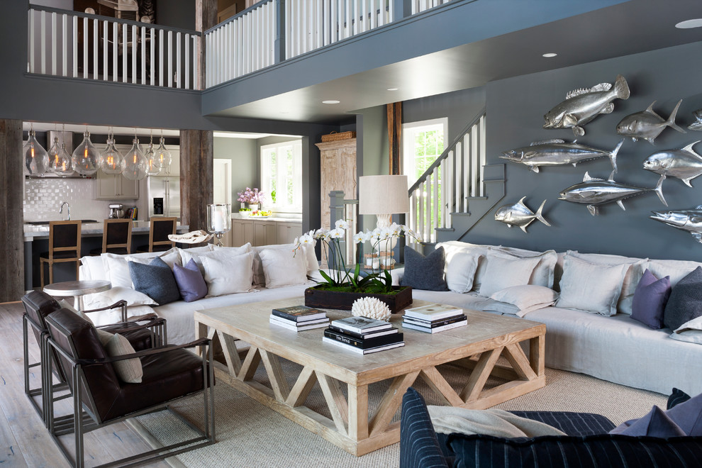 Immagine di un soggiorno stile marinaro aperto con pareti blu e parquet chiaro