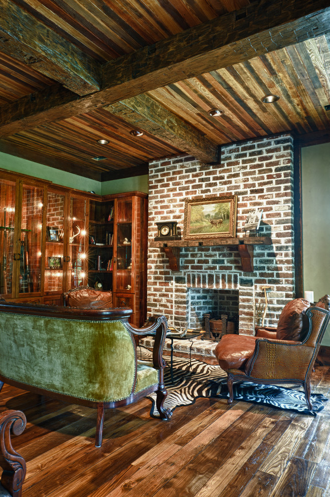 Mittelgroßes, Fernseherloses, Offenes Klassisches Wohnzimmer mit brauner Wandfarbe, braunem Holzboden, Kamin, Kaminumrandung aus Backstein und braunem Boden in Charleston