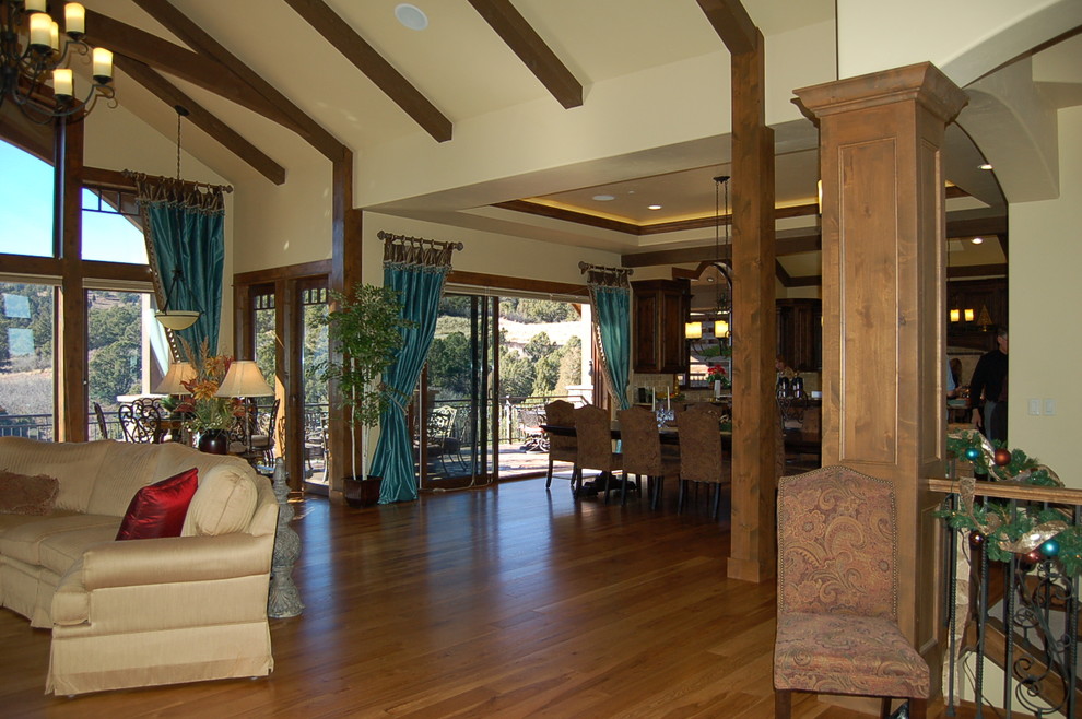 Modelo de salón para visitas abierto rural con paredes beige y suelo de madera en tonos medios
