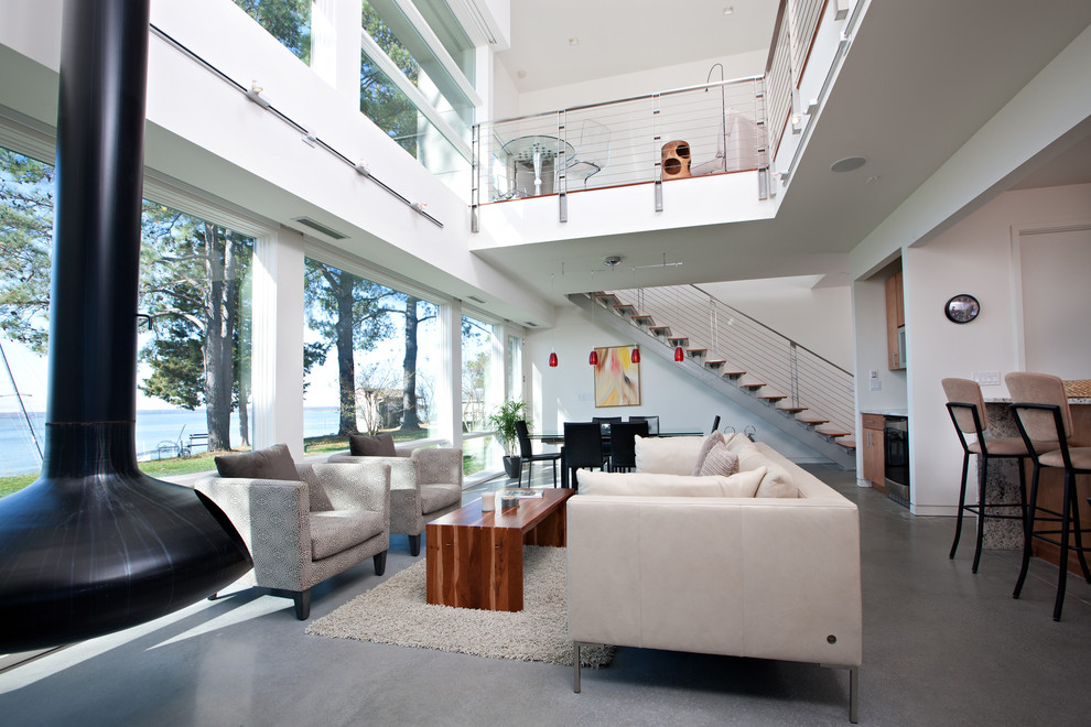 Пример оригинального дизайна: гостиная комната в современном стиле с белыми стенами, подвесным камином и бетонным полом