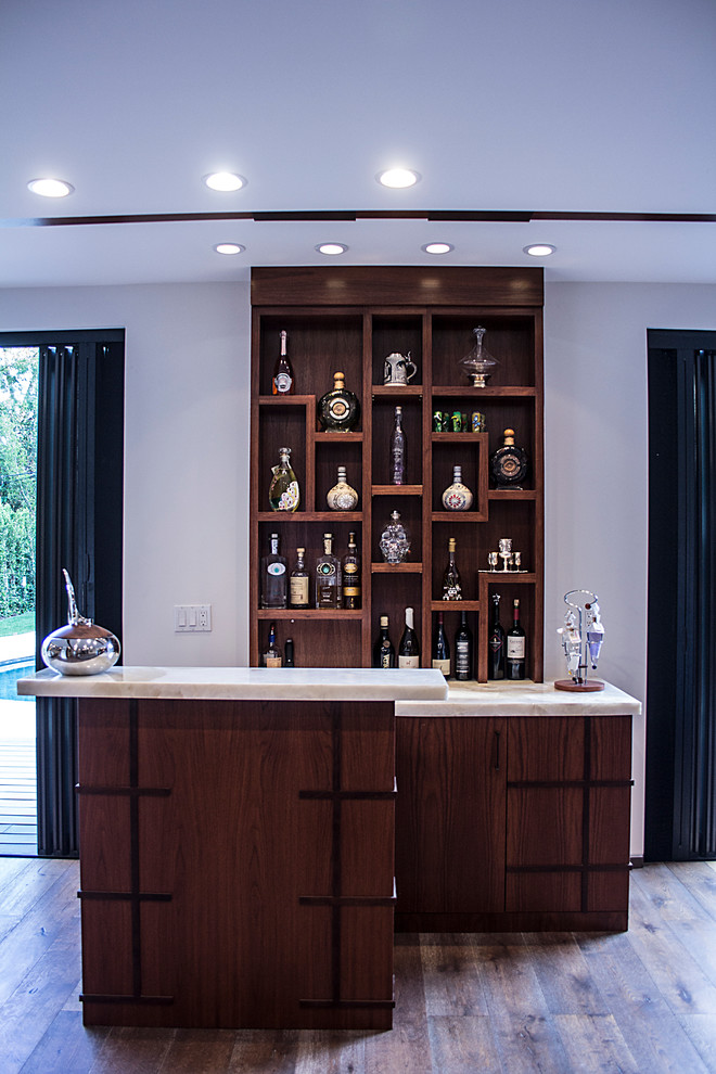 На фото: открытая гостиная комната среднего размера в стиле модернизм с домашним баром, белыми стенами, светлым паркетным полом, двусторонним камином, фасадом камина из камня и телевизором на стене