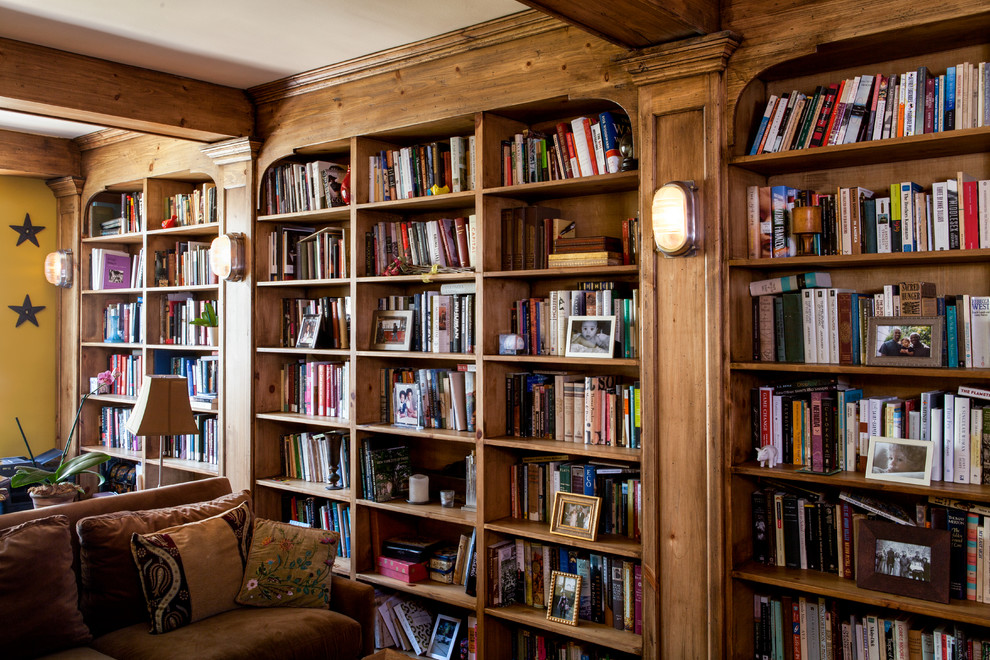 Example of a mid-sized mountain style enclosed living room library design in New York with yellow walls and no tv