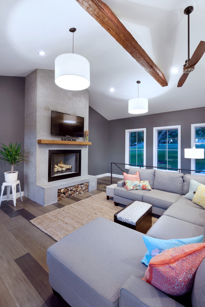 Идея дизайна: открытая гостиная комната в стиле модернизм с серыми стенами, паркетным полом среднего тона, стандартным камином, фасадом камина из бетона, телевизором на стене и разноцветным полом