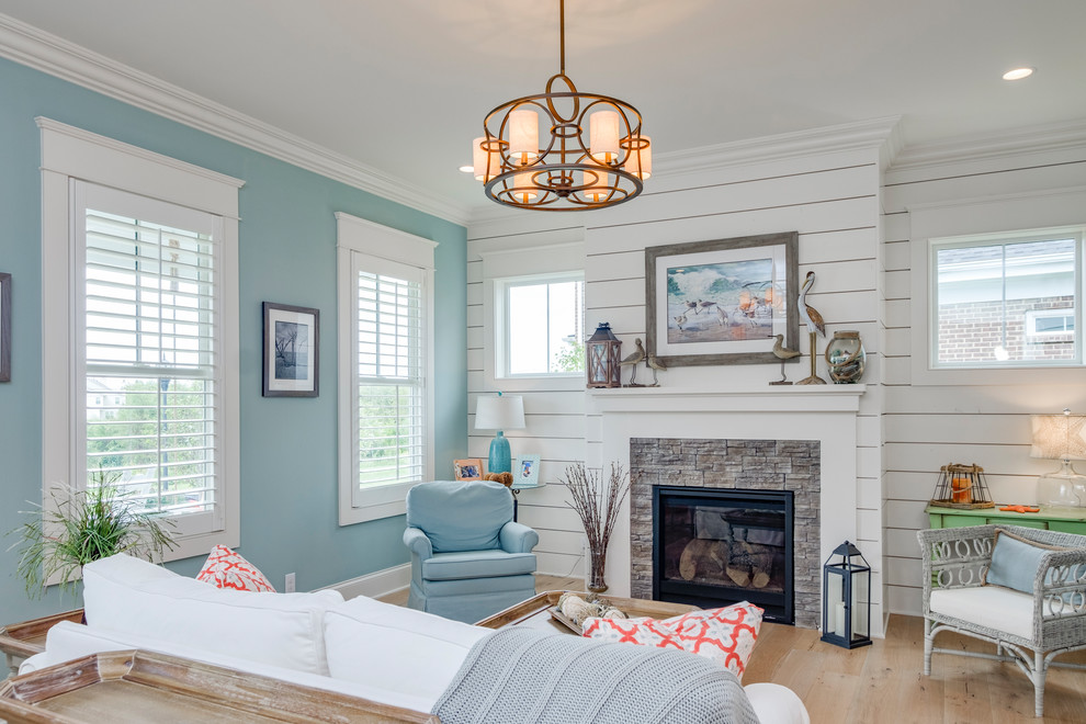 Fernseherloses Maritimes Wohnzimmer mit blauer Wandfarbe, hellem Holzboden, Kamin, Kaminumrandung aus Stein und beigem Boden in Louisville