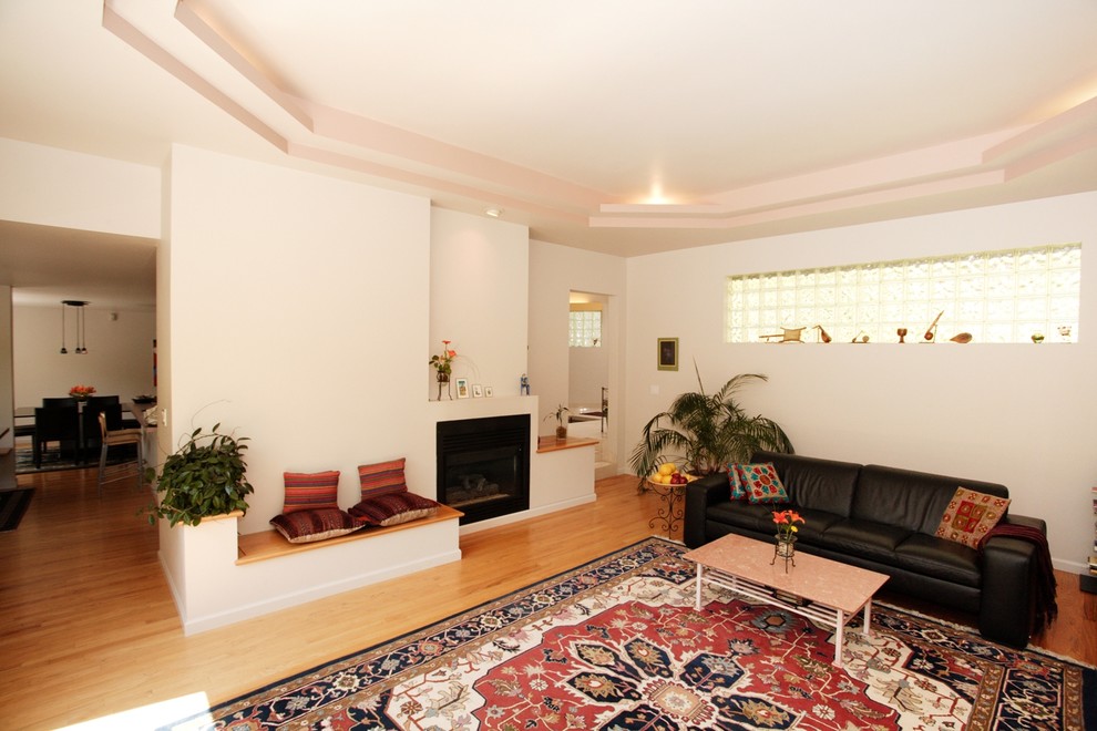 Cette photo montre un grand salon méditerranéen ouvert avec un mur gris, un manteau de cheminée en plâtre et un téléviseur indépendant.