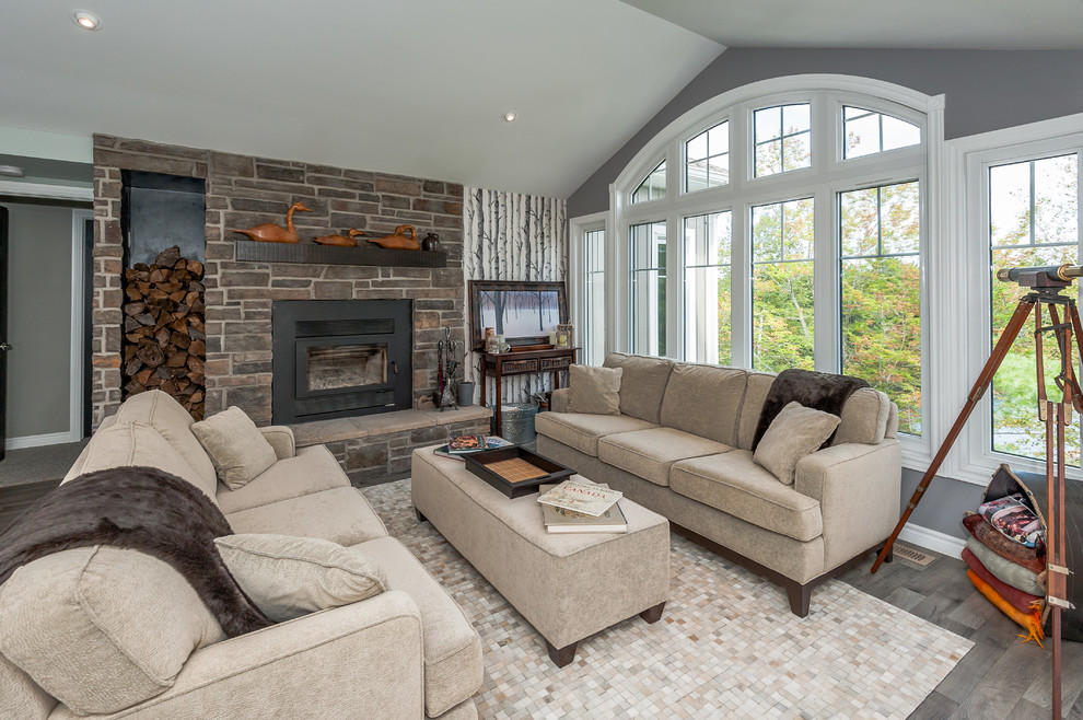 Medium sized traditional open plan living room in Other with brown floors, grey walls, dark hardwood flooring, a standard fireplace and a stone fireplace surround.