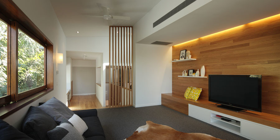 Идея дизайна: открытая гостиная комната в современном стиле с с книжными шкафами и полками, белыми стенами, ковровым покрытием и отдельно стоящим телевизором