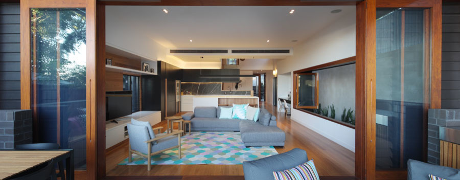 Immagine di un soggiorno design aperto con libreria, pareti bianche, moquette e TV autoportante