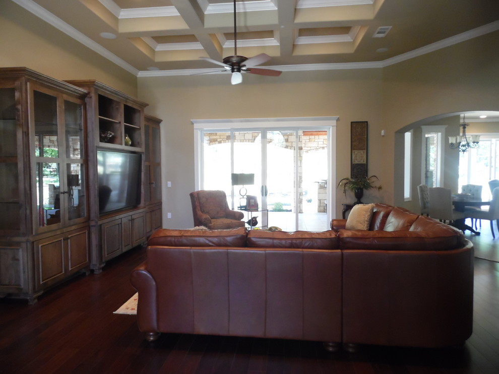 Großes, Offenes Klassisches Wohnzimmer ohne Kamin mit beiger Wandfarbe, dunklem Holzboden und freistehendem TV in Austin