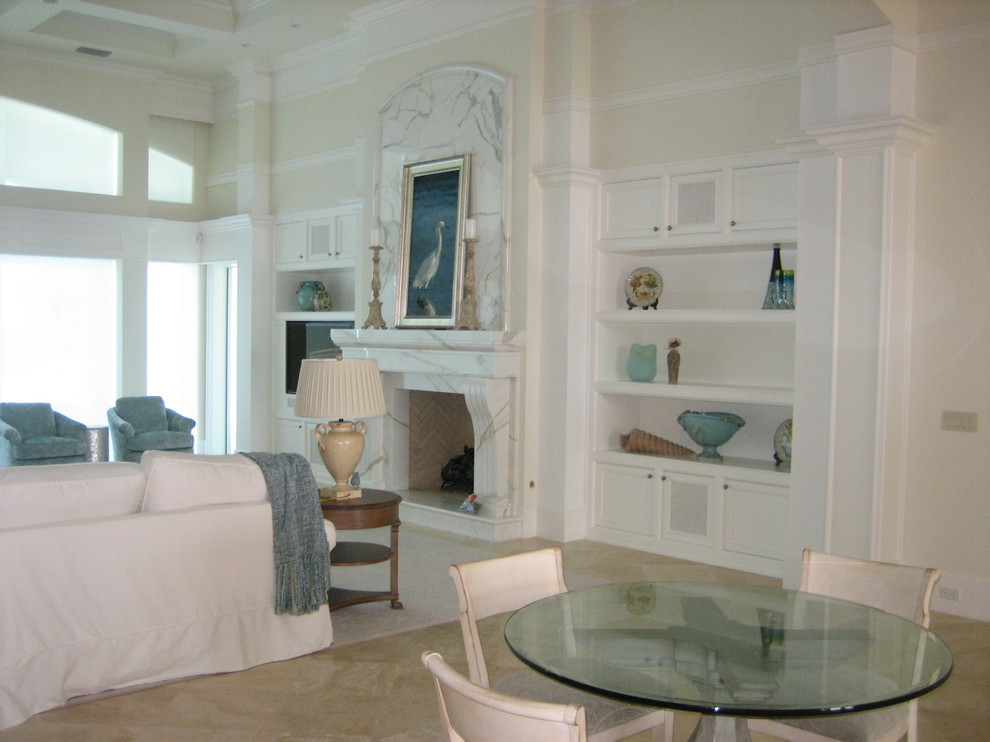 На фото: гостиная комната среднего размера в классическом стиле с бежевыми стенами, стандартным камином, фасадом камина из камня и мультимедийным центром с
