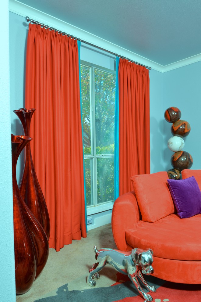 Cette image montre un salon design avec un mur bleu et moquette.