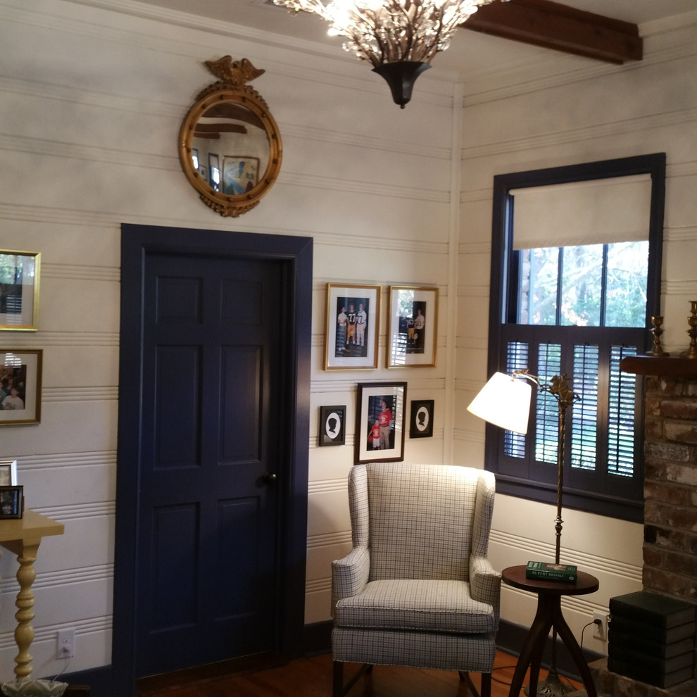 На фото: гостиная комната среднего размера в классическом стиле с белыми стенами, паркетным полом среднего тона, стандартным камином, фасадом камина из кирпича и коричневым полом с