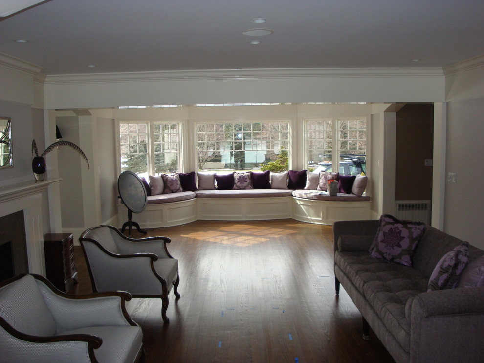 Aménagement d'un grand salon classique ouvert avec un mur violet, un sol en bois brun, une cheminée standard, un manteau de cheminée en carrelage et aucun téléviseur.