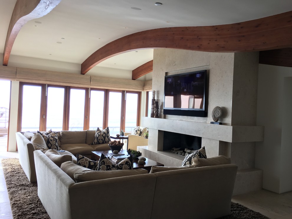 Свежая идея для дизайна: большая открытая гостиная комната в морском стиле с бежевыми стенами, полом из керамической плитки, стандартным камином, фасадом камина из камня, телевизором на стене и бежевым полом - отличное фото интерьера