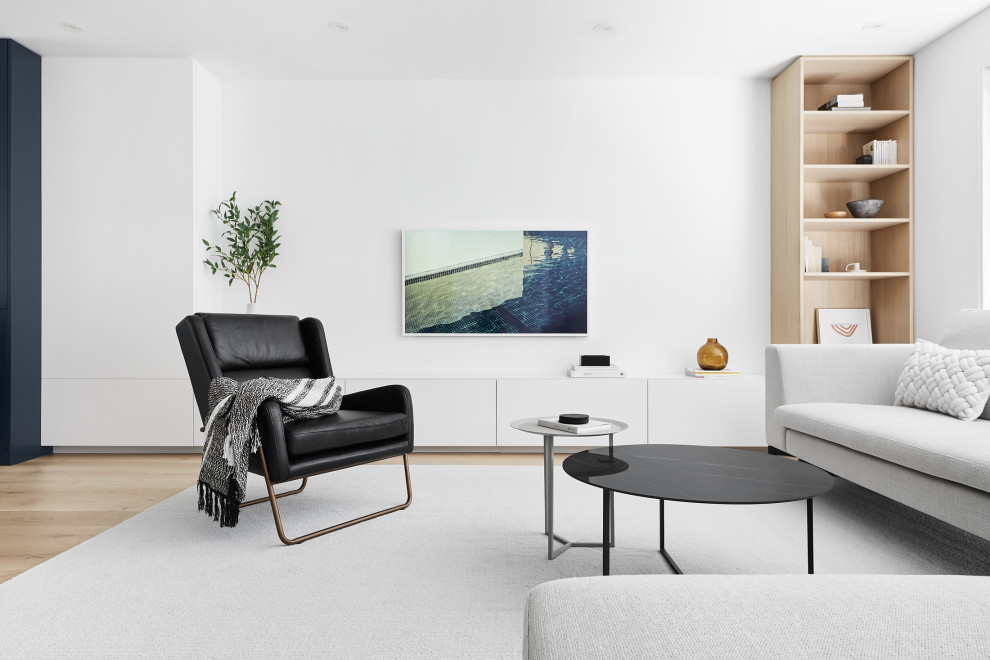 Свежая идея для дизайна: открытая гостиная комната среднего размера в стиле модернизм с белыми стенами, светлым паркетным полом и телевизором на стене - отличное фото интерьера
