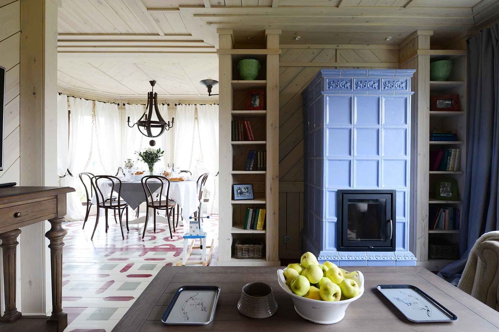 Пример оригинального дизайна: гостиная комната в стиле фьюжн с стандартным камином и фасадом камина из плитки