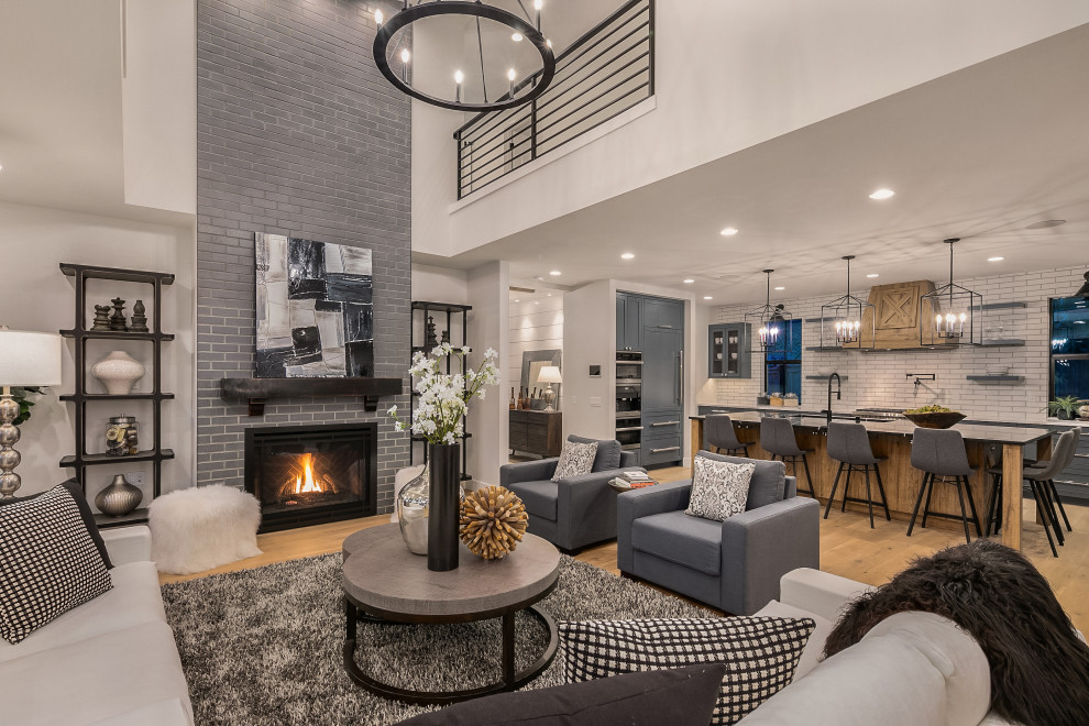 Photo of a large country formal open plan living room in Seattle with white walls, a standard fireplace, no tv, black floors and a brick fireplace surround.