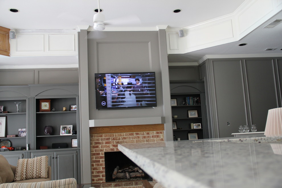 Источник вдохновения для домашнего уюта: открытая гостиная комната среднего размера в современном стиле с серыми стенами, полом из керамогранита, стандартным камином, фасадом камина из кирпича и телевизором на стене