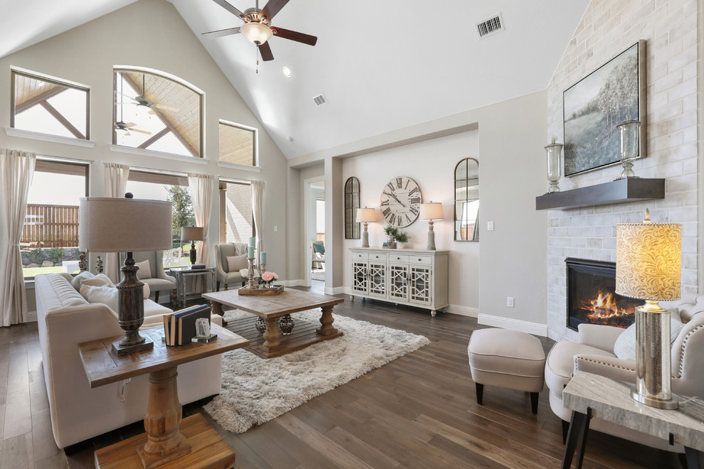 This is an example of a medium sized classic open plan living room in Dallas with beige walls, light hardwood flooring, a corner fireplace, a brick fireplace surround and brown floors.