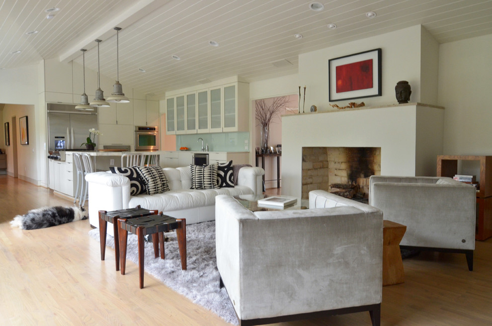Immagine di un soggiorno classico aperto con sala formale, pareti bianche, parquet chiaro, camino classico e nessuna TV