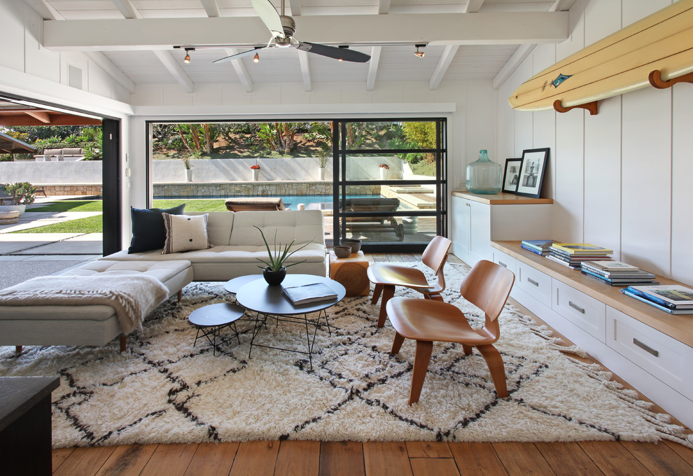 Modernes Wohnzimmer mit weißer Wandfarbe und braunem Holzboden in Orange County