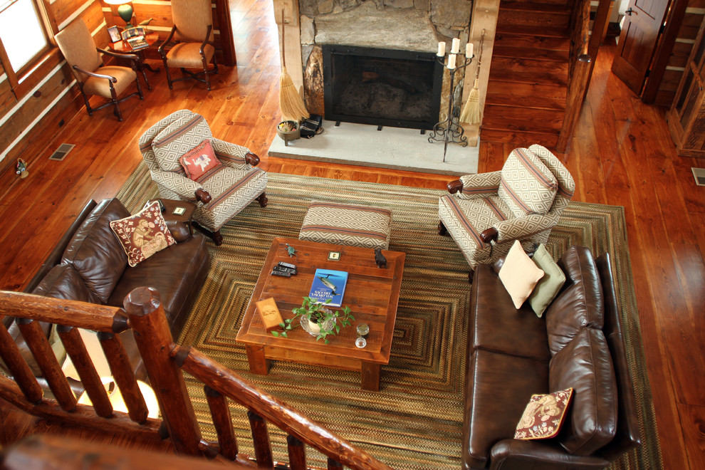 Ejemplo de salón para visitas tipo loft rural grande sin televisor con suelo de madera en tonos medios, todas las chimeneas y marco de chimenea de piedra
